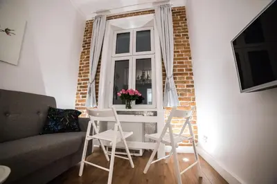 a living room with two chairs and a window at Saint Philip in Kraków