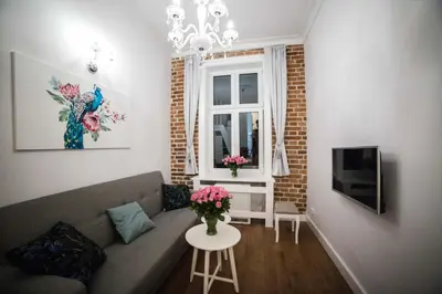 a living room with a couch and a table with flowers at Saint Philip in Kraków