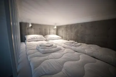 a large bed with white sheets and pillows on it at Saint Philip in Kraków