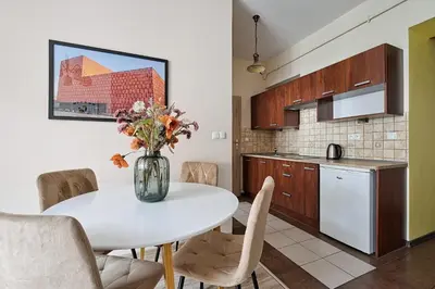a kitchen with a white table with a vase of flowers at Urban Nest Apartments Józefitów 5 in Kraków