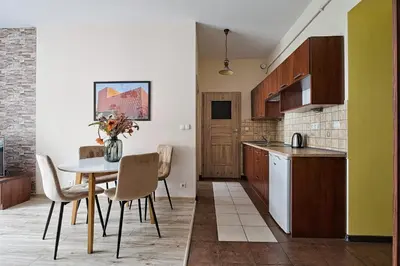 a kitchen with a table and chairs in a room at Urban Nest Apartments Józefitów 5 in Kraków