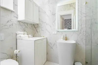 a white bathroom with a toilet and a sink at Golden Fish - New Apartment - Old Town in Kraków