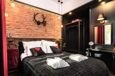 a bedroom with a brick wall and a bed with pillows at Wooden Horse - New Apartment - Old Town in Kraków