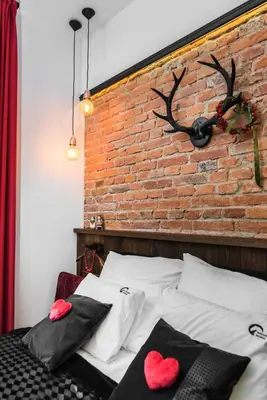 a bedroom with a brick wall and a bed with red hearts at Wooden Horse - New Apartment - Old Town in Kraków
