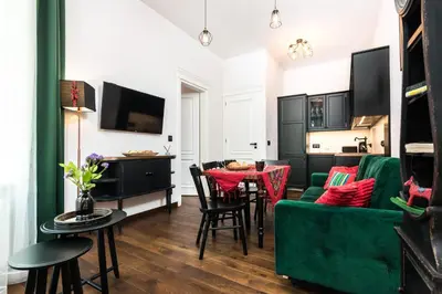 a living room with a green couch and a table at Wooden Horse - New Apartment - Old Town in Kraków