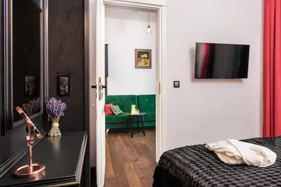 a bedroom with a bed and a television on a wall at Wooden Horse - New Apartment - Old Town in Kraków