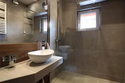 a bathroom with a bowl sink and a shower at Rainbow Apartments 1 Premium in Kraków