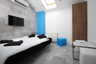 a bedroom with a bed and a tv on a wall at Rainbow Apartments 1 Premium in Kraków