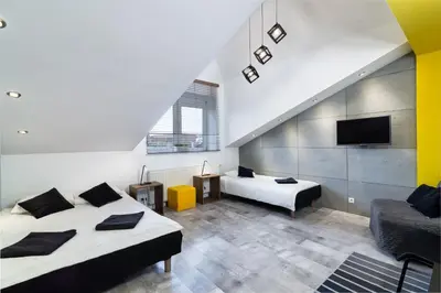 a room with two beds and a tv and a couch at Rainbow Apartments 1 Premium in Kraków