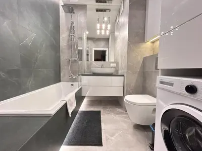 a bathroom with a toilet and a sink and a washing machine at ApartmentPrestige Central Station in Kraków