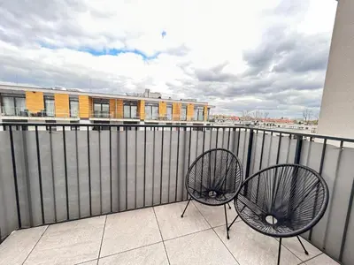 a pair of chairs sitting on a balcony at ApartmentPrestige Central Station in Kraków