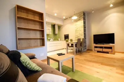 a living room with a couch and a tv and a table at ApartmentPrestige Central Station in Kraków