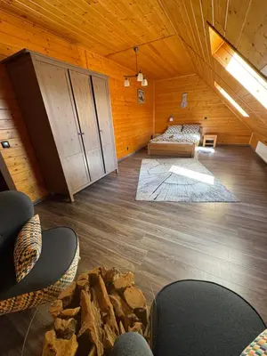 a room with a bed and chairs in a cabin at Beskid House Kurów in Kurów