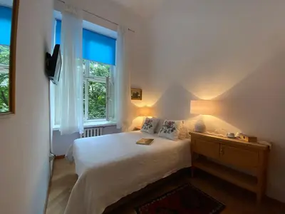 a bedroom with a white bed and a window at Boutique Aparthotel in Kraków