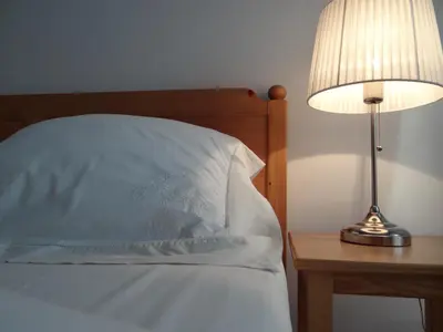 a bed with a pillow and a lamp on a table at Boutique Aparthotel in Kraków