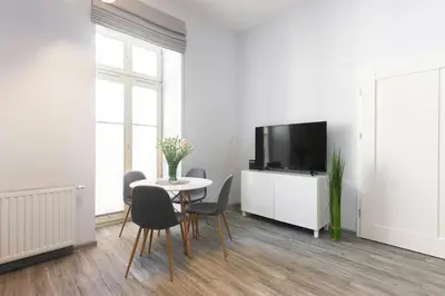 a white living room with a table and a tv at Luxury Apartments Old Town Topolowa in Kraków