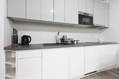 a kitchen with white cabinets and a black counter top at Luxury Apartments Old Town Topolowa in Kraków
