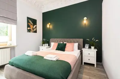 a bedroom with a bed with a green wall at Luxury Apartments Old Town Topolowa in Kraków