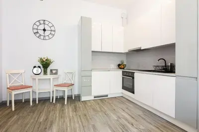 a kitchen with white cabinets and a table and chairs at Luxury Apartments Old Town Topolowa in Kraków
