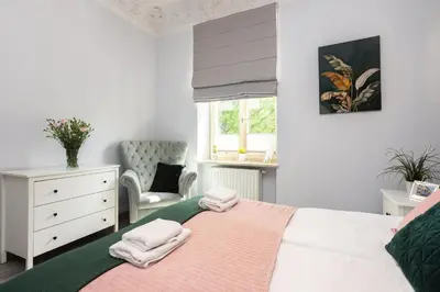 a bedroom with a bed and a chair and a window at Luxury Apartments Old Town Topolowa in Kraków
