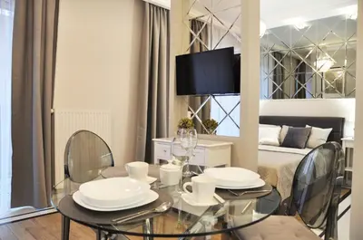 a dining room with a table and chairs and a bed at Rakowicka 22H - studio by Homeprime in Kraków