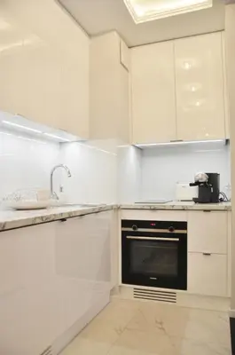 a kitchen with white cabinets and a black oven at Rakowicka 22H - studio by Homeprime in Kraków