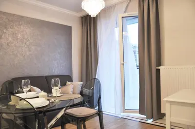a dining room with a table and chairs and a window at Rakowicka 22H - studio by Homeprime in Kraków