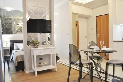 a room with a bed and a table and a tv at Rakowicka 22H - studio by Homeprime in Kraków
