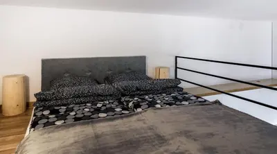 a bedroom with a large bed with black pillows at Miodowe mieszkanko in Kraków