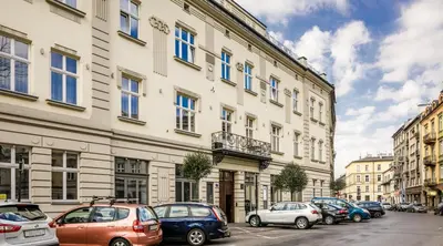 a row of cars parked in front of a building at Miodowe mieszkanko in Kraków