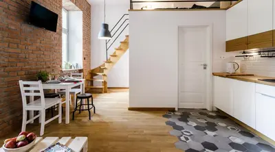 a kitchen and dining room with a brick wall at Miodowe mieszkanko in Kraków