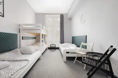a room with two bunk beds and a table at Moon Hostel Kraków in Kraków