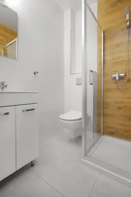 a white bathroom with a shower and a toilet at Moon Hostel Kraków in Kraków