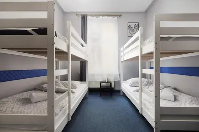 a bedroom with two bunk beds with a desk at Moon Hostel Kraków in Kraków