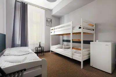 a bedroom with two bunk beds and a window at Moon Hostel Kraków in Kraków
