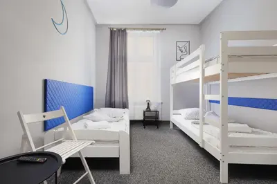 a bedroom with two bunk beds and a couch at Moon Hostel Kraków in Kraków