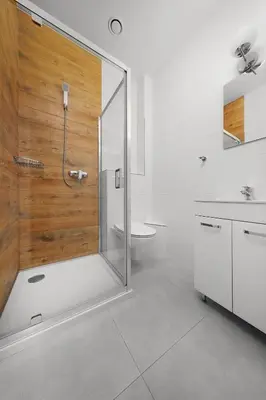 a bathroom with a shower with a glass door at Moon Hostel Kraków in Kraków