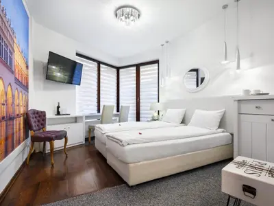 a bedroom with a bed and a desk in it at Parkside Apartments Old Town in Kraków