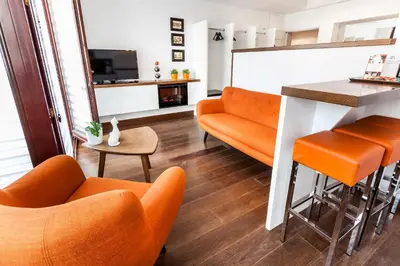 a living room with orange chairs and a bar at Parkside Apartments Old Town in Kraków