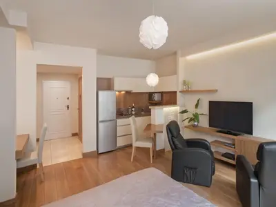 a living room with a kitchen and a dining room at Parkside Apartments Old Town in Kraków