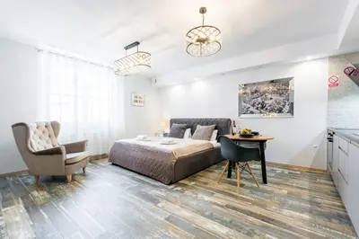 a bedroom with a bed and a desk and a chair at Old Town Premium Kazimierz Apartments in Kraków