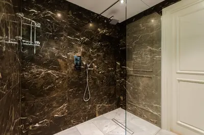 a bathroom with a black marble shower stall at Old Town Premium Kazimierz Apartments in Kraków