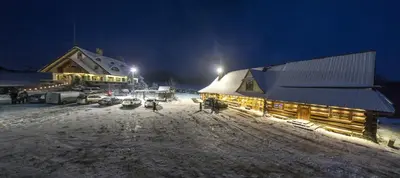 a building covered in snow at night with lights at Krakowiacy i Górale in Krzyszkowice