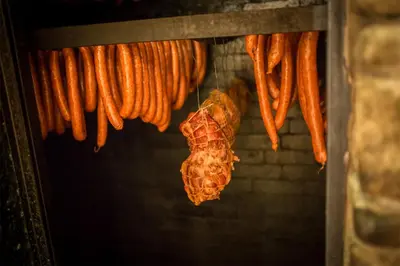 a bunch of sausages hanging from a grill at Krakowiacy i Górale in Krzyszkowice