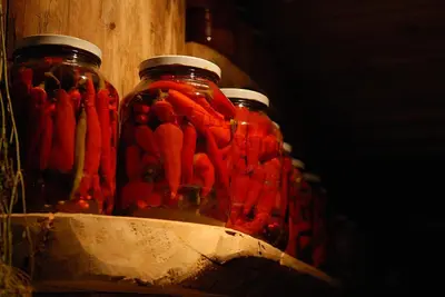 two jars filled with red peppers sitting on a shelf at Krakowiacy i Górale in Krzyszkowice