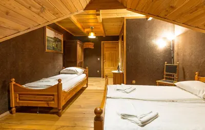 two beds in a room with wooden ceilings at Krakowiacy i Górale in Krzyszkowice