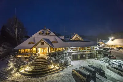a building with cars parked in the snow at night at Krakowiacy i Górale in Krzyszkowice