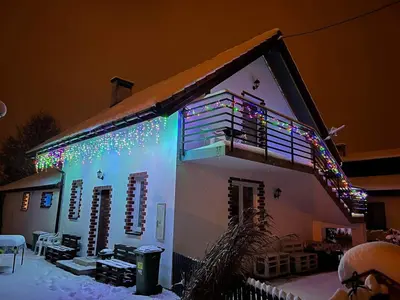 a house with christmas lights on the side of it at Gdow Riverside Apartments and Tours in Gdów