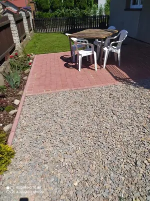 a patio with a table and chairs on a brick path at Gdow Riverside Apartments and Tours in Gdów