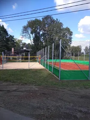 a tennis court with a net in a park at Gdow Riverside Apartments and Tours in Gdów